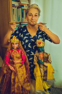 Portrait of Maria Coelho holding two puppets